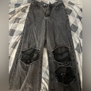 black baggy jeans with three big holes below the knee